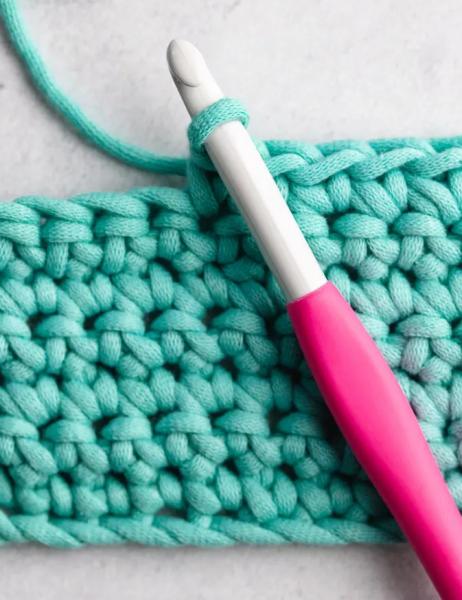 multiple hands crocheting bright yarns