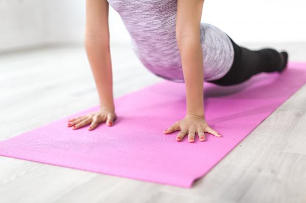 woman stretching on pink yoga mat